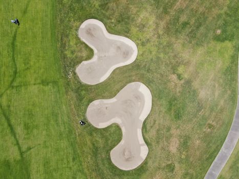 Aerial top view of a green golf course during sunny day, California