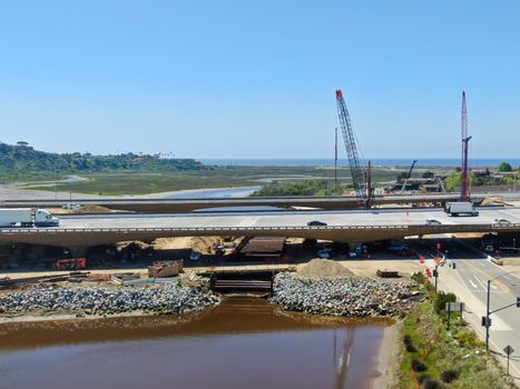 Aerial view of highway bridge construction over small river, San Diego, California, USA