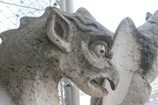 Gargoyle or chimera on the Cathedral of Notre Dame de Paris looks at the Eiffel Tower, Paris, France. Gargoyles are the Gothic landmarks in Paris. Vintage skyline of Paris with an old demon statue.