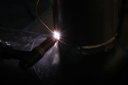 Welder performs welding work semi-automatic electric arc welding. Stainless steel pipe welding. Pipe production. MIG welding.