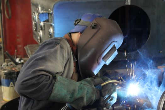 Welder performs welding work semi-automatic electric arc welding. MIG welding.