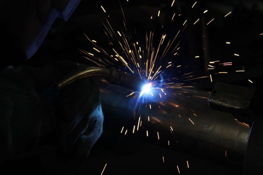 Metal welding. Sparks from electric heating. Iron, materials.Artistic welding sparks light, industrial background .