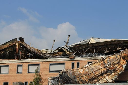 Facade of an industrial building after a fire against a blue sky