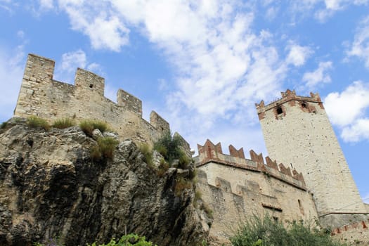 Ancient castle wall with tower in Malcesine on Garda Lake, Italy