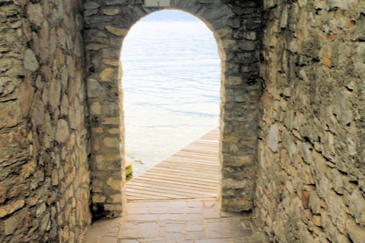 ancient stone gate on the lake in Italy