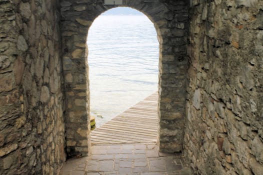 ancient stone gate on the lake in Italy