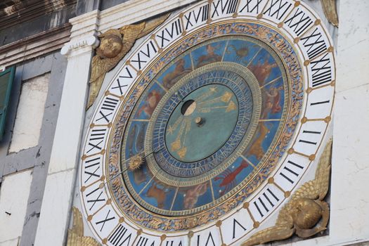 the clock tower with historical astronomical clock in Brescia, Italy