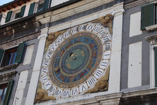 the clock tower with historical astronomical clock in Brescia, Italy