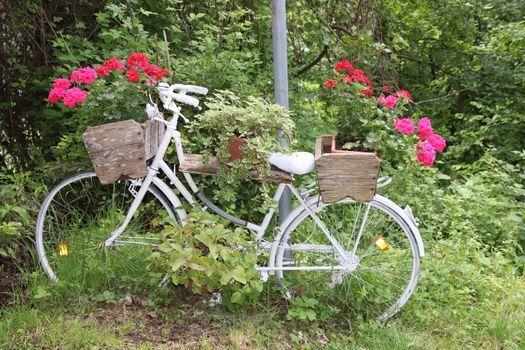 Decorative flower stand in the shape of a bicycle with flower pots and flowers in them