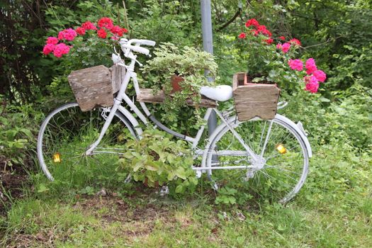 Decorative flower stand in the shape of a bicycle with flower pots and flowers in them