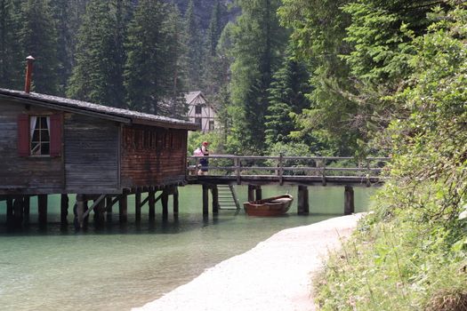 Braies Lake in Dolomites mountains forest trail in background, Sudtirol, Italy. Lake Braies is also known as Lago di Braies. The lake is surrounded by forest which are famous for scenic hiking trails.