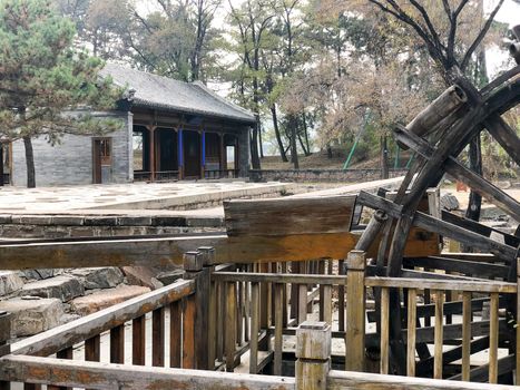 Water mill wheel in a calm little river and little pavilion on the background at The Imperial Summer Palace of The Mountain Resort in Chengde. China. 