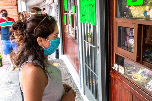 Alvaro Obregon, CDMX. Mexico. June 10, 2020. Woman buys cookies with surgical mask for the new normal. Covid 19