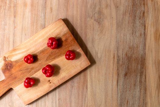 Apple and serrano peppers on chopping board on wooden surface. copy space