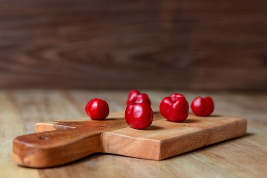 Apple and serrano peppers on chopping board on wooden surface. copy space