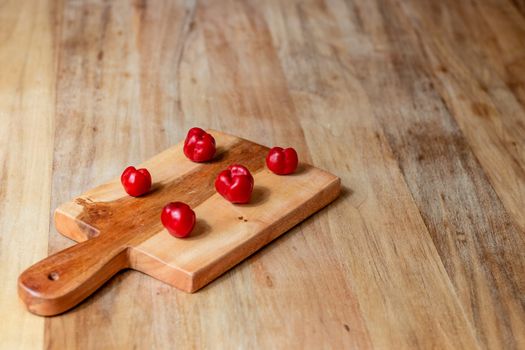 Apple and serrano peppers on chopping board on wooden surface. copy space