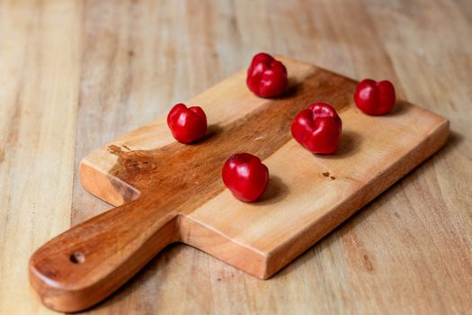 Apple and serrano peppers on chopping board on wooden surface. copy space