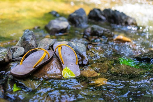 Slippers were placed on the rock in the water