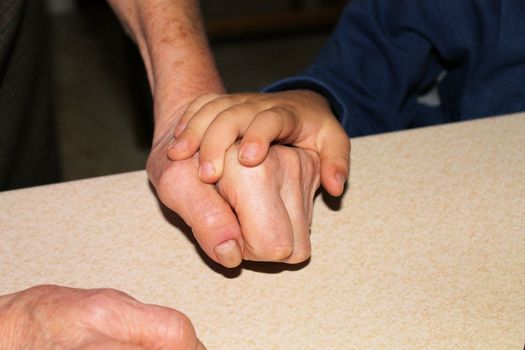 90 year old grandmother, close up of young woman hand holding with tenderness an elderly senior person hands, monochrome photo