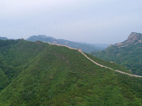Aerial view of Great Wall of China. Famous landmark Great Wall and mountains located in Hebei province next to Beijing. 