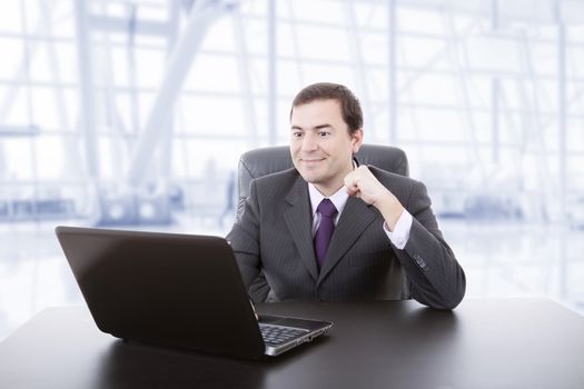 happy businessman working with is laptop, at the office