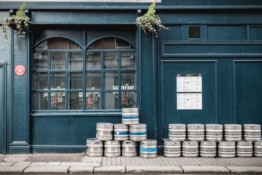 Dublin, Ireland - February 12, 2019 - beer barrels piled up on the street in front of an Irish pub on a winter day