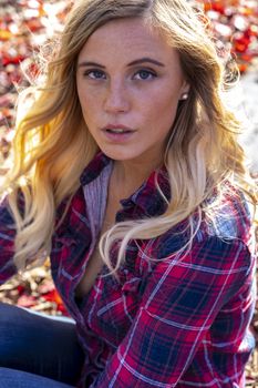 A gorgeous blonde model enjoys a Autumn day outdoors in a park