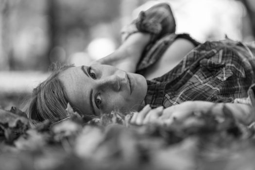 A gorgeous blonde model enjoys a Autumn day outdoors in a park
