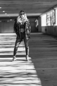 A gorgeous blonde model poses in a parking deck on an autumn day