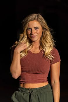 A gorgeous blonde model poses in a parking deck on an autumn day