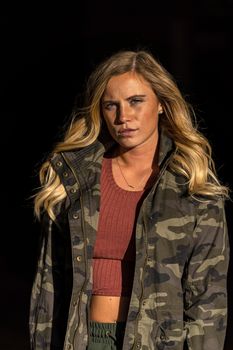 A gorgeous blonde model poses in a parking deck on an autumn day