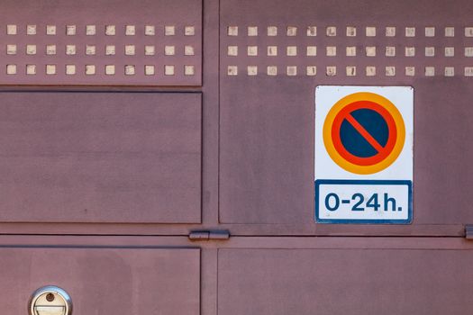 sign prohibiting parking from 0 to 24h on a garage door in Spain