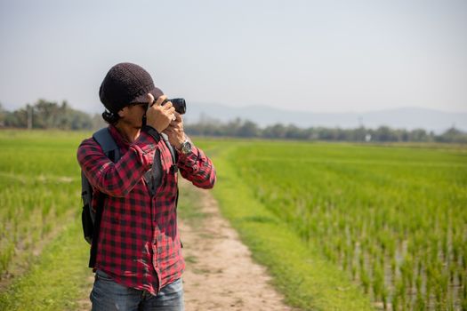 Asian man tourist is using a camera for taking pictures of scenery and mountain .Relax time on holiday concept travel