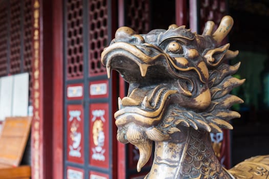 Golden color dragon head sculpture in a buddhist temple, China