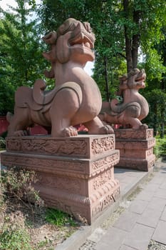 Two large lion stone statues in a buddhist temple, Chengdu, China