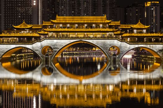 Chengdu Anshun bridge at night reflecting in the JinJiang river dark and gold colors in Sichuan Province, China