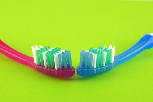 Two tooth-brushes over bright green