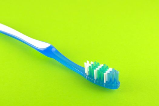 Tooth-brush over bright green. Shallow DOF. 