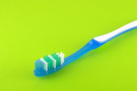 Tooth-brush over bright green. Shallow DOF. 