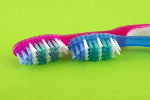 Two tooth-brushes over bright green