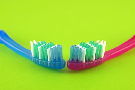 Two tooth-brushes over bright green