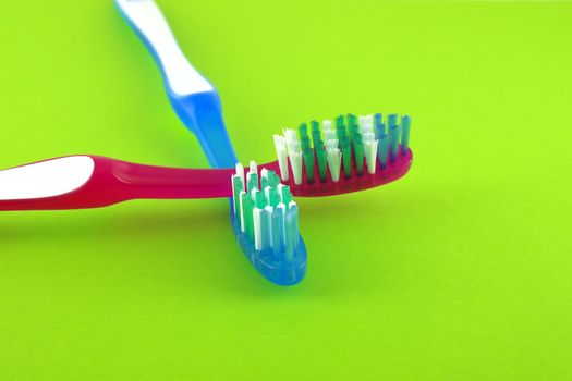 Two tooth-brushes over bright green