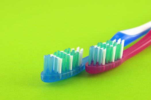 Two tooth-brushes over bright green