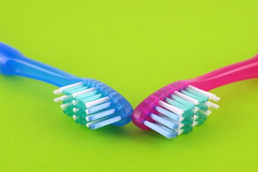 Two tooth-brushes over bright green