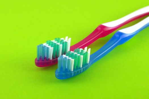 Two tooth-brushes over bright green