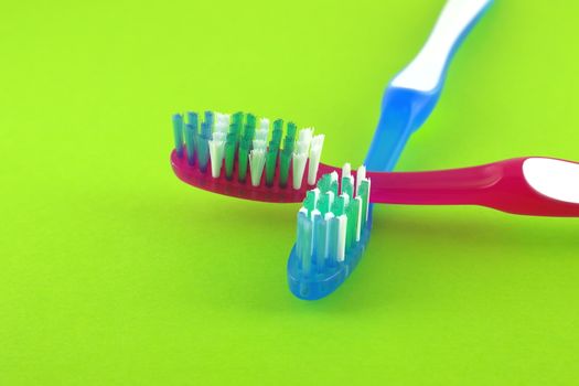 Two tooth-brushes over bright green