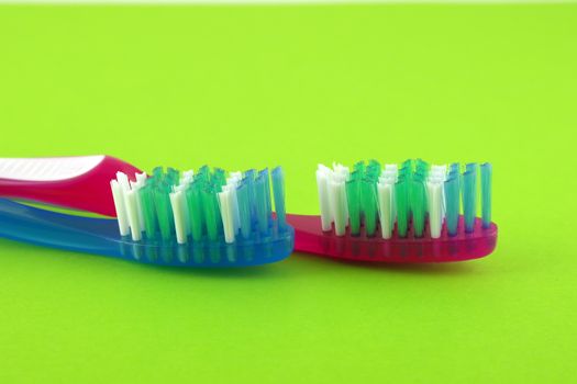 Two tooth-brushes over bright green