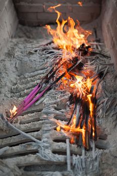 Burning incense sticks with flames in a chinese buddhist temple