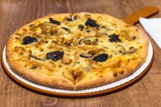 Pizza with truffles close up on a wooden table