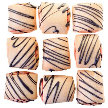 Cookies rolls with strawberry jam and chocolate icing top view isolated on a white background.